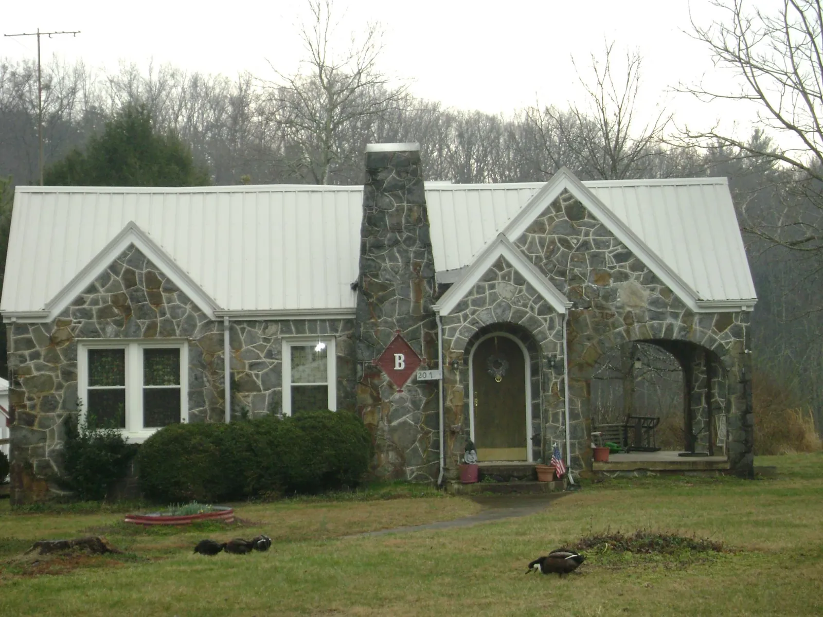 White metal roof on a stone cottage with steep gables in Elwood